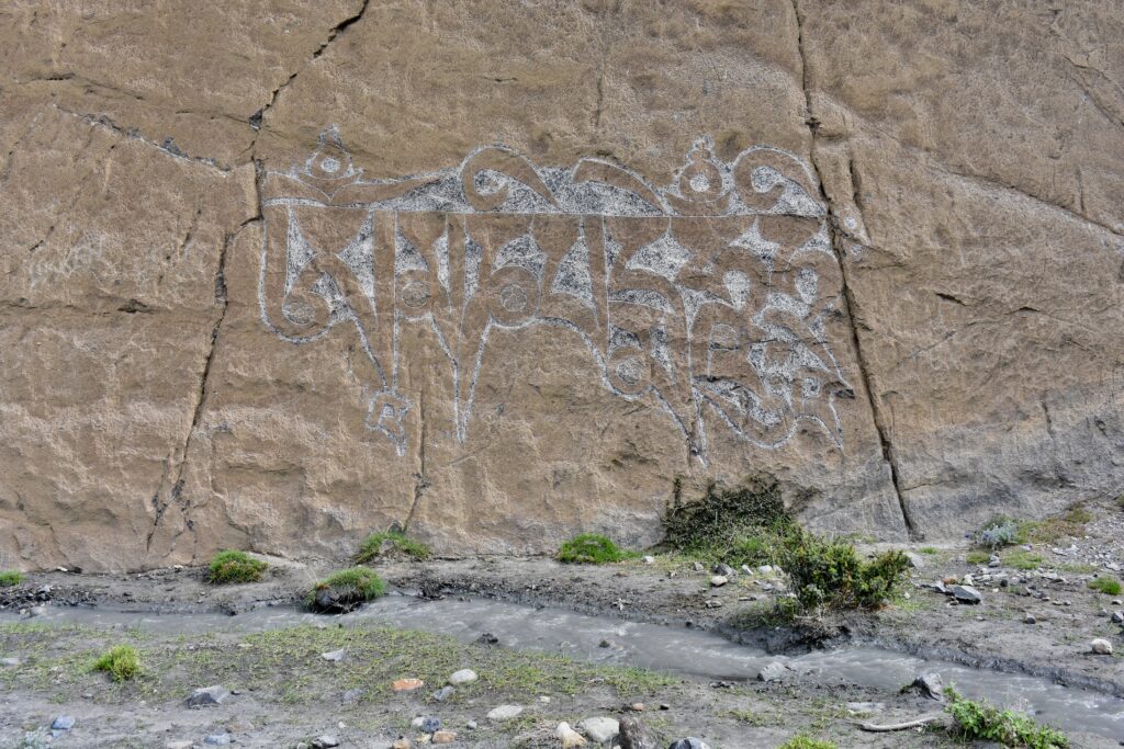 Image of mantra carved into rock wall