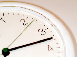 Close up of an analog clock showing the minute hand