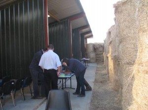 Last minute preparations in front of the shed with calf pens.  Note hay bales used as sound-deadeners in front of shed, there is an identical shed to the right of the bales.