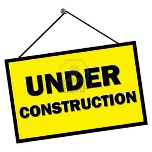 9579863-under-construction-sign-hanging-from-nail-isolated-over-white