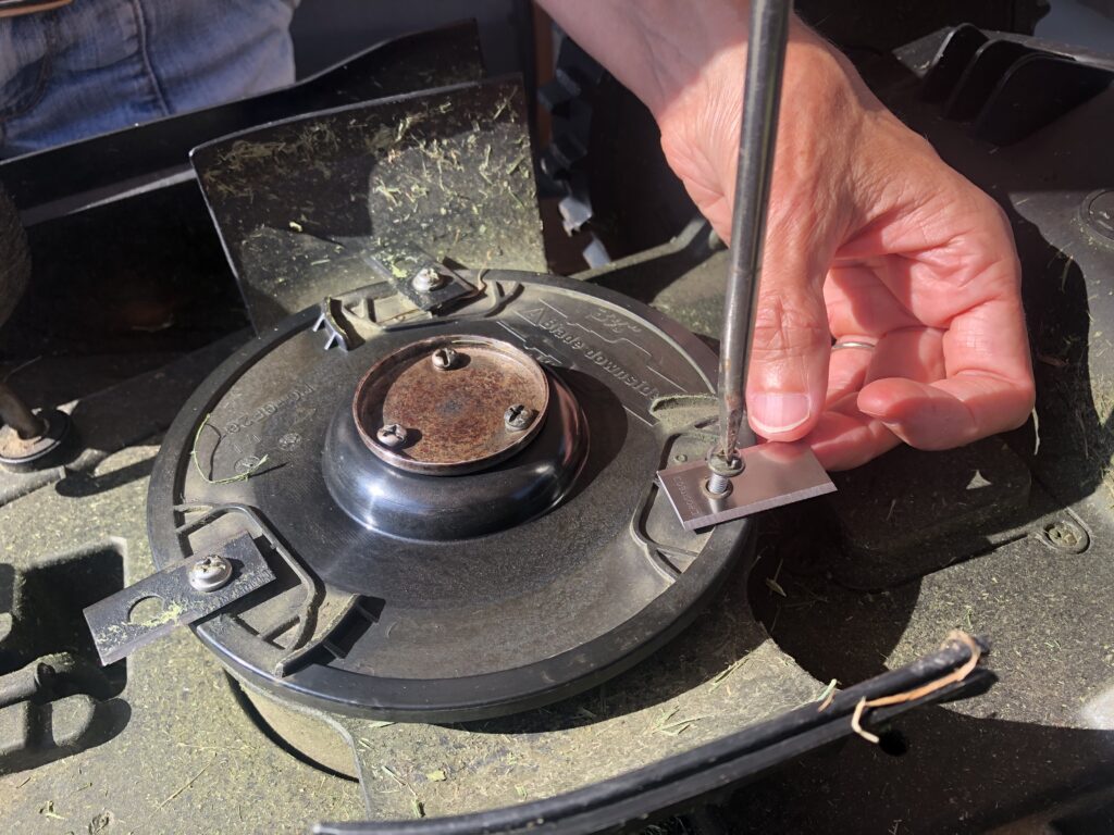 Screwing in a new blade to a WORX Landroid robotic mower.