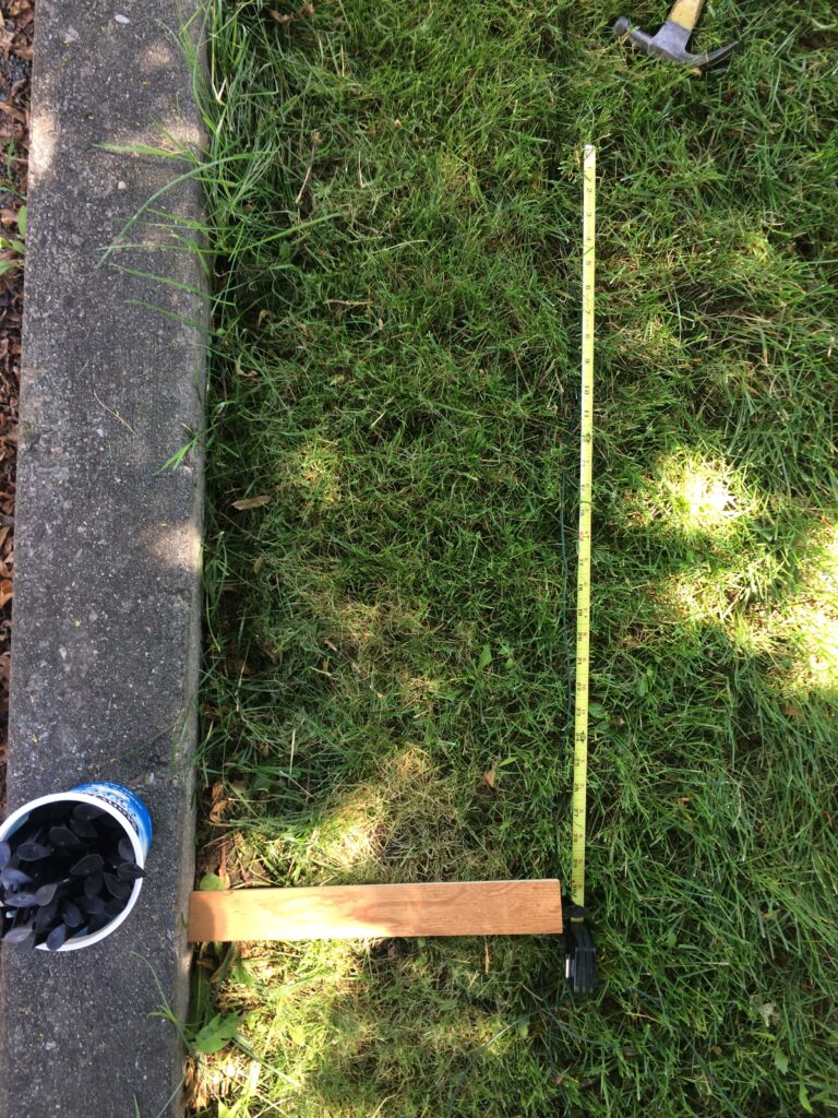 Overhead picture of a piece of wood and a measuring tape measuring 14" and 24" , respectively.