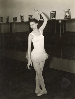 Polly Nulty, wearing a leotard with tutu and ballet shoes, demonstrates a dance position.