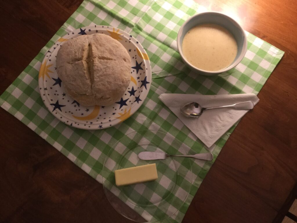 Loaf of homamde bread and bowl of cheese soup