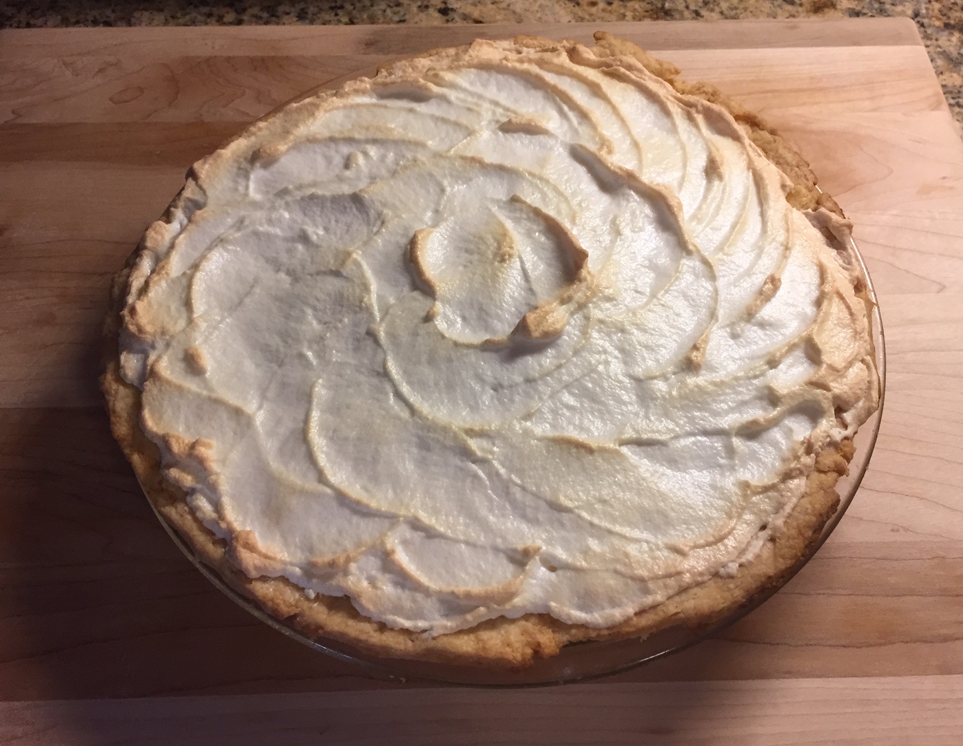 A pie with a meringue crust on a counter.