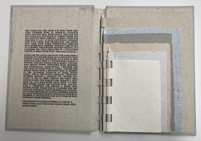 Image shows an open book with text printed on one side and six different samples of paper on the other.