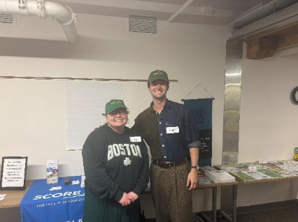 Small Business Advocate Izzy Gogarty and CAP Service-Learning Student Aiden Holmes tabling at Mercy Connections