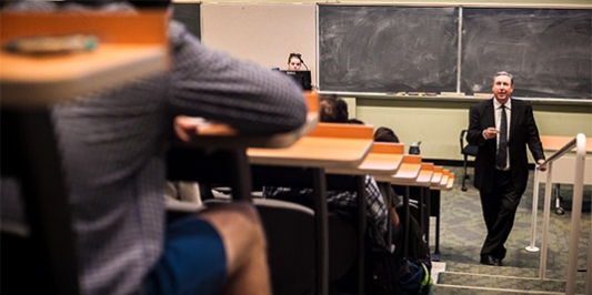 Professor lecturing at the front of a lecture hall