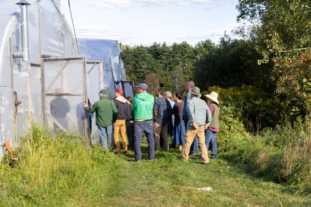 Group of farmers looking into  a high tunnel