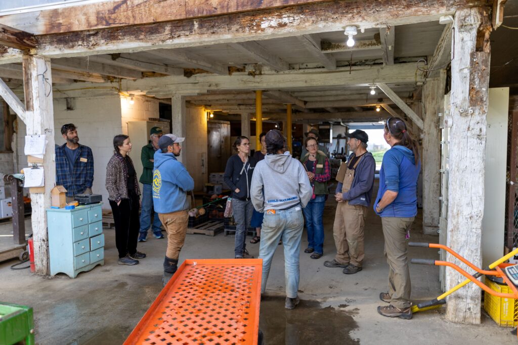 Group of farmers in barn storage area talking