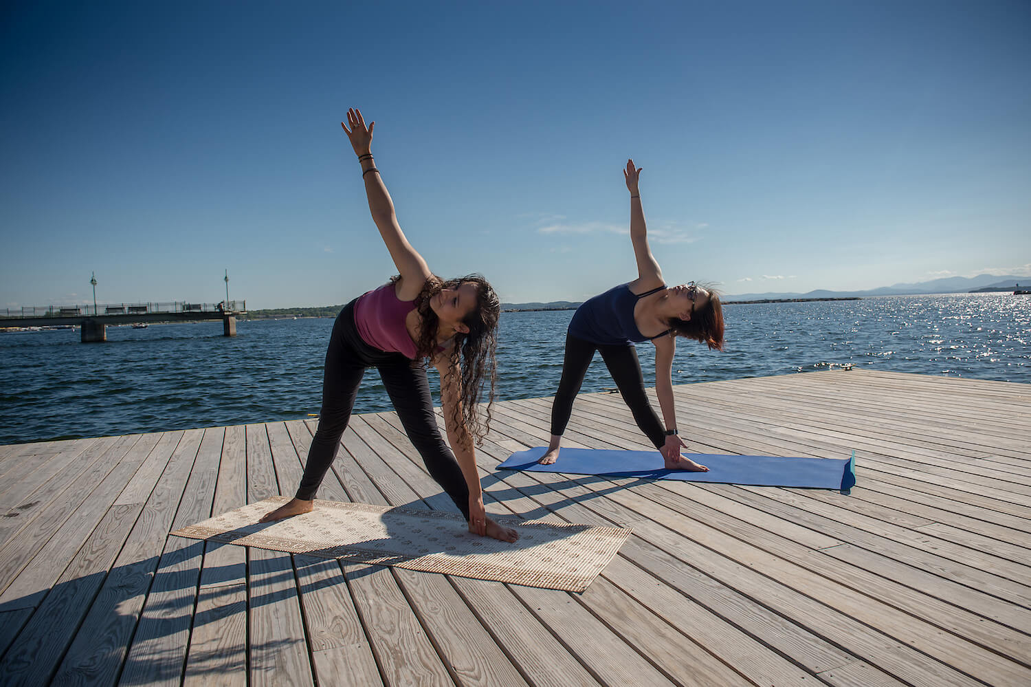 UVM students practice yoga on a deck on Lake Champlain