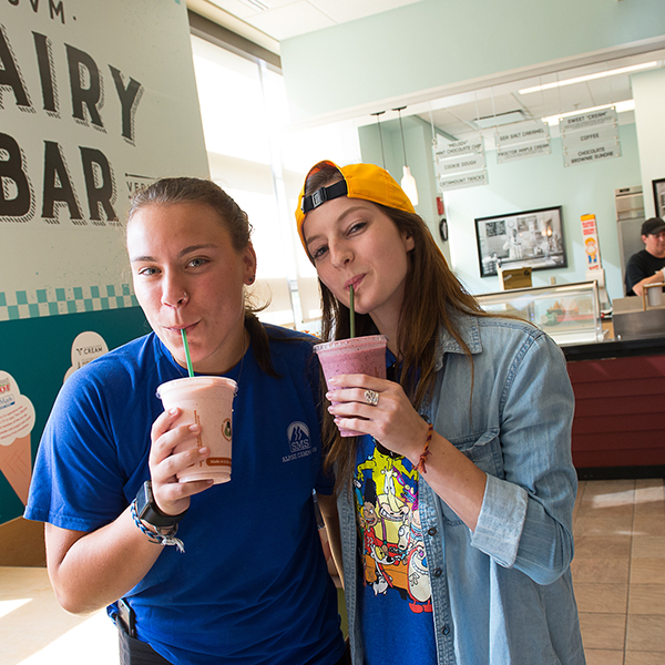 Two students enjoy milkshakes from the UVM Dairy Bar in the Davis Student Center